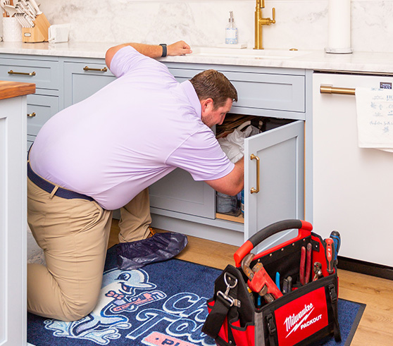 Picture of the CEO of Charles Towne Plumbing fixing a garbage disposal under a sink